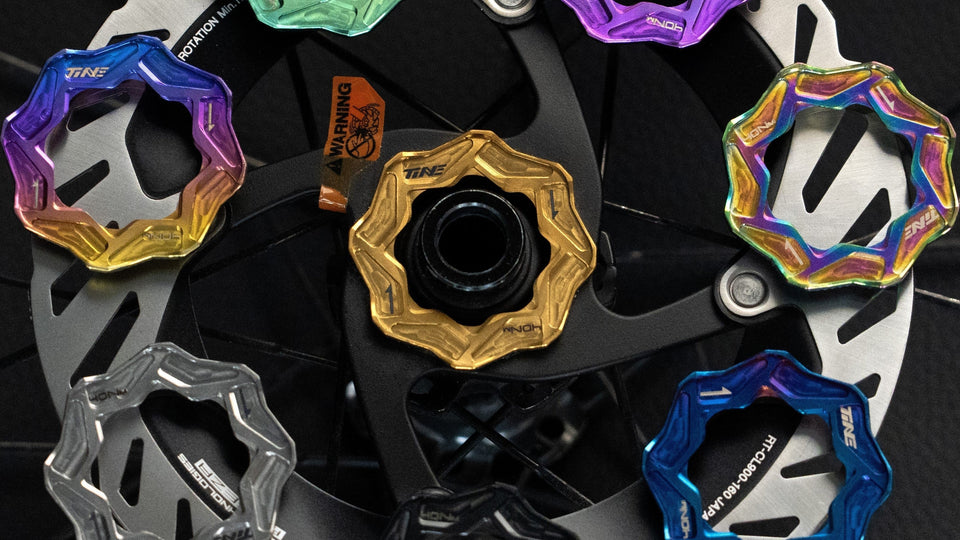 Multiple TiNE disc centerlock caps in colorful anodized designs