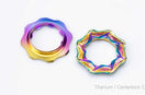 Two TiNE titanium centerlock caps in rainbow anodized finishes