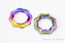 Two TiNE titanium centerlock caps in rainbow anodized finishes