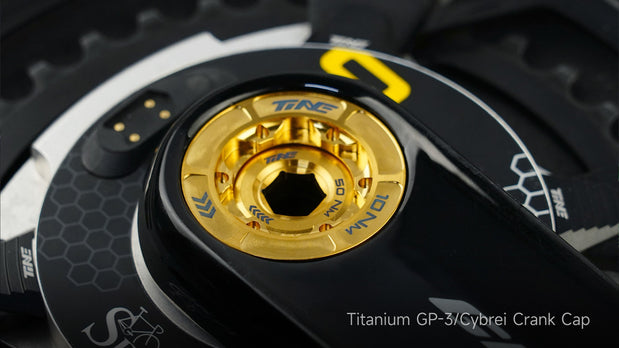 Gold titanium TiNE GP-3 crank cap with black honeycomb crank