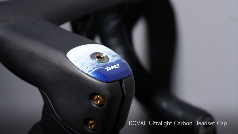 TiNE blue-anodized carbon stem cap on black handlebar