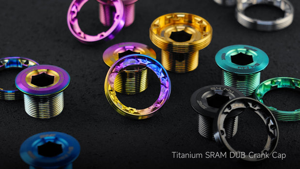 TiNE TECH SRAM DUB titanium crank caps in purple, gold, teal on dark surface