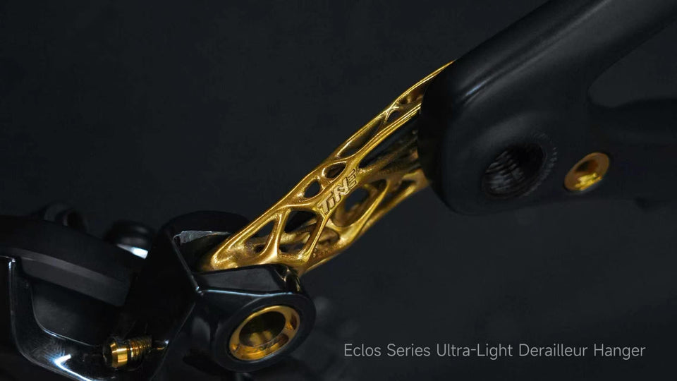 TiNE Tech Eclos ultra-light titanium derailleur hanger with gold lattice design