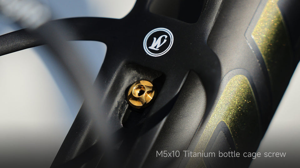 TiNE Tech gold titanium M5x10 bottle cage bolt on black bike frame