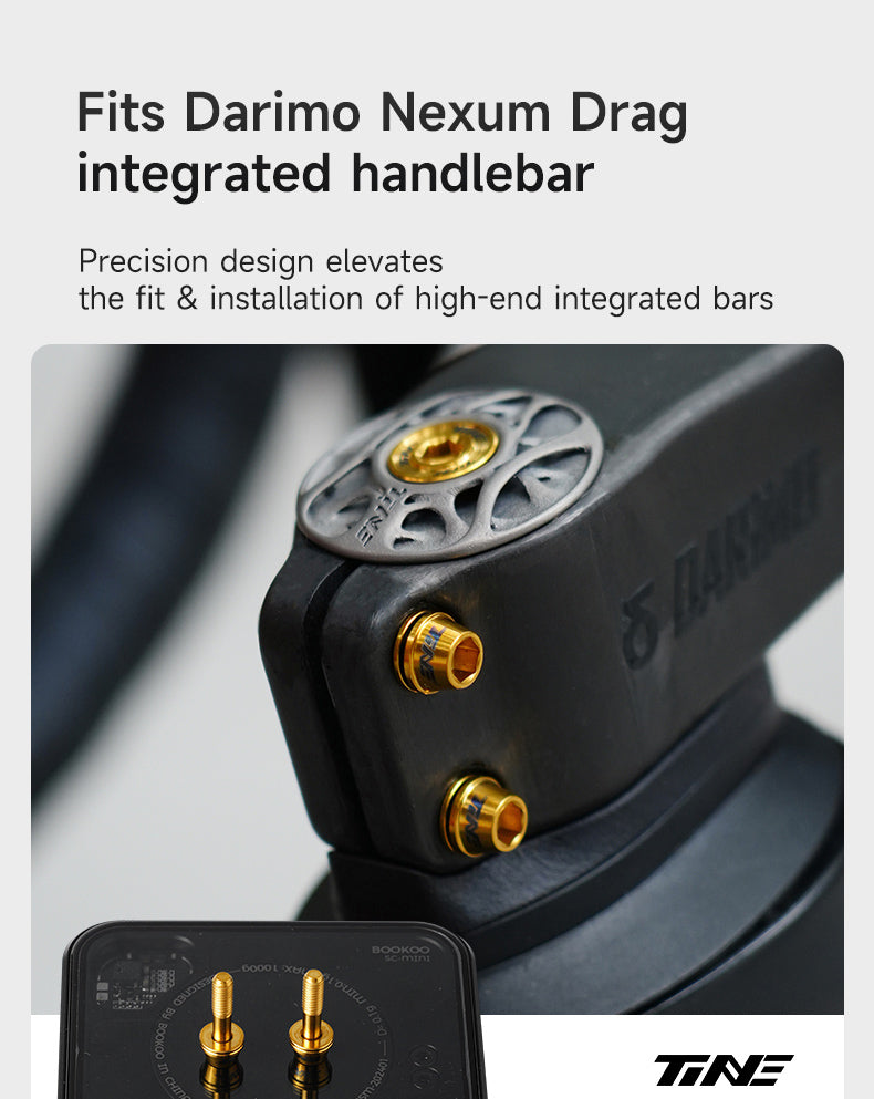 Close-up of a black integrated handlebar stem with gold anodized titanium bolts and a silver top cap, highlighting precision components for a high-end bicycle fit and installation.