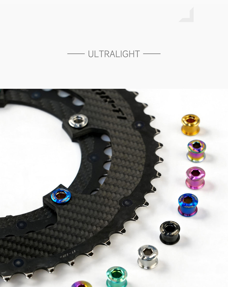 Close-up of a carbon fiber bicycle chainring with ultralight titanium bolts in various anodized colors arranged beside it on a white surface.
