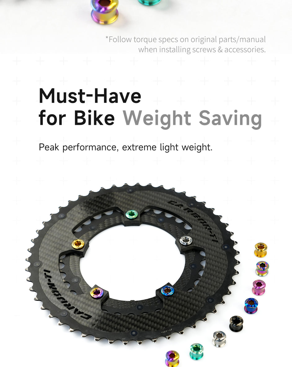 Close-up of a black carbon double chainring secured with colorful lightweight titanium bolts arranged on a white surface, highlighting bike weight-saving components.